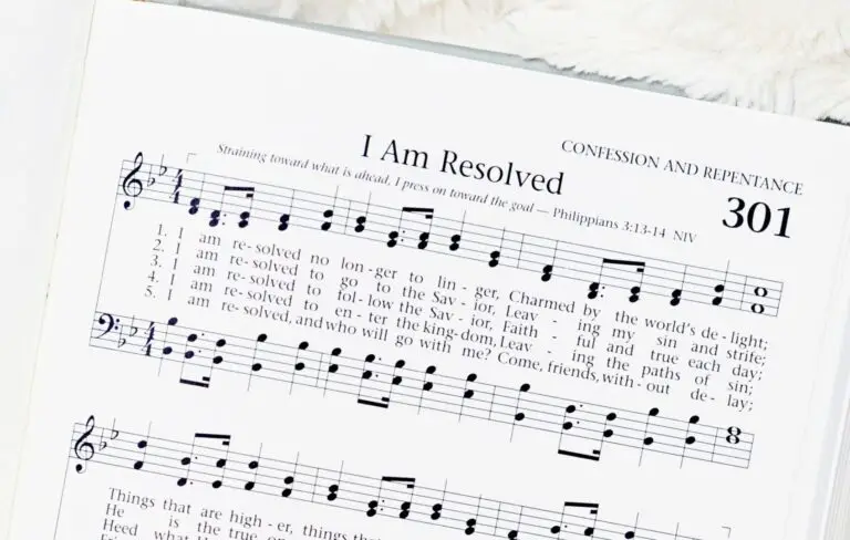 Hymnal open on white background to sheet music and words for "I Am Resolved"